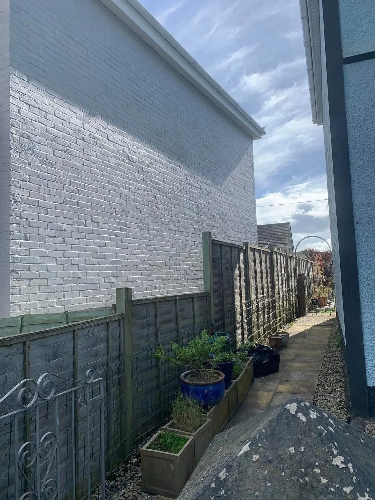 Freshly painted brick wall after preparation and masonry paint in Ottery St Mary
